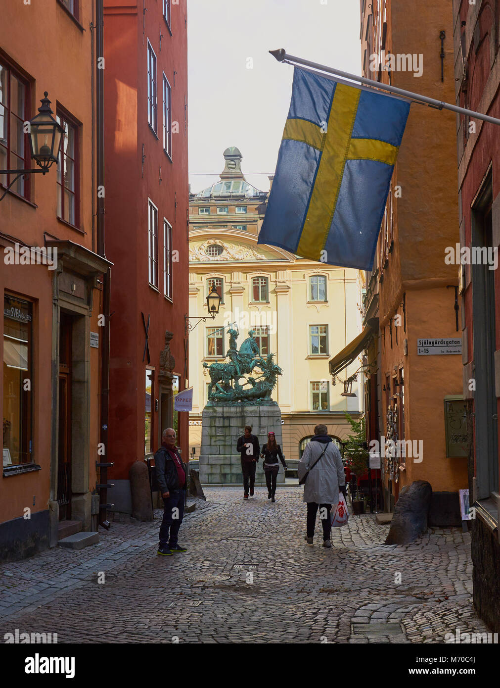 La bandera sueca y la estatua de San Jorge y el dragón, Gamla Stan, Estocolmo, Suecia, Escandinavia. Foto de stock