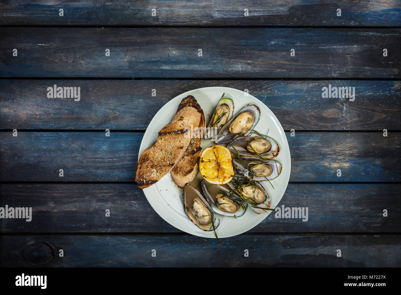 Los mejillones y las tostadas de pan en una placa blanca. Vista superior Foto de stock