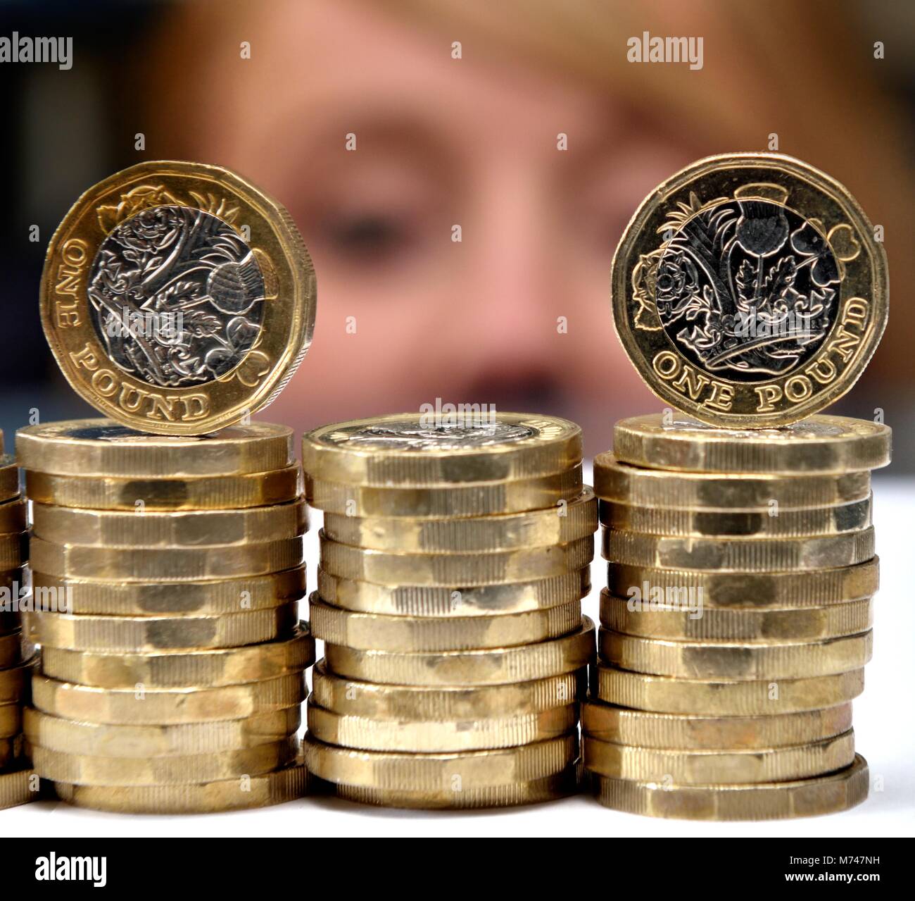 Pilas de monedas de una libra de cerca con cara de mujer en el fondo de dinero concepto de ahorro isa Foto de stock