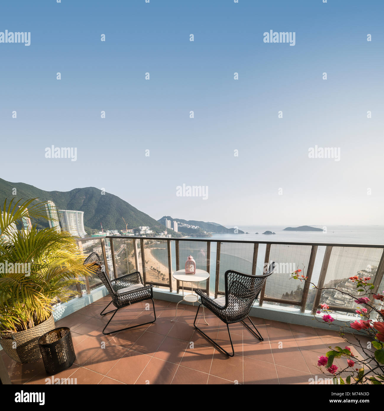 Mesa y sillas con una relajante vista a la playa desde un balcón en la Bahía Repulse. Hong Kong. Foto de stock