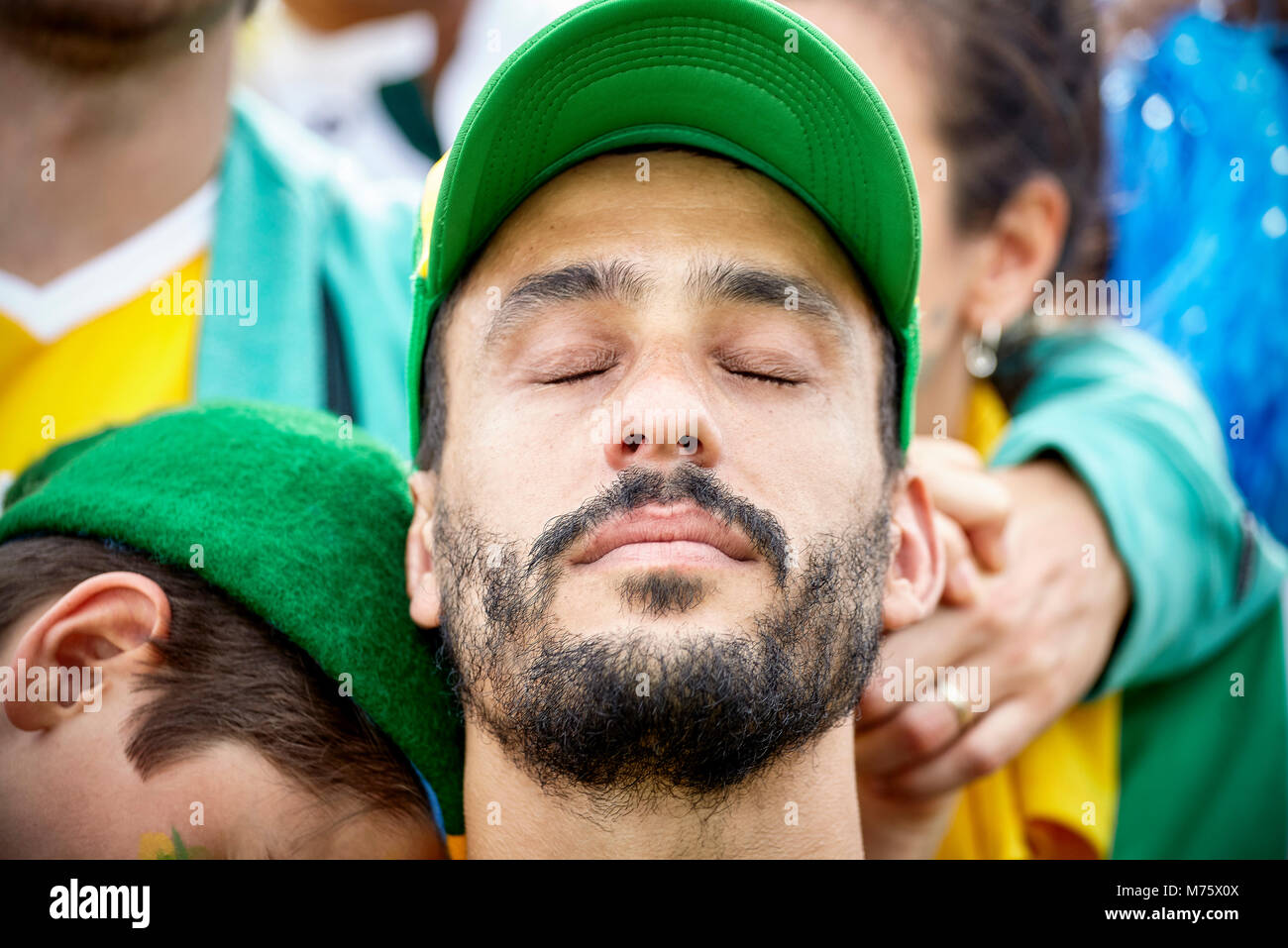 Fan de fútbol con la cabeza hacia atrás y los ojos cerrados en decepción Foto de stock