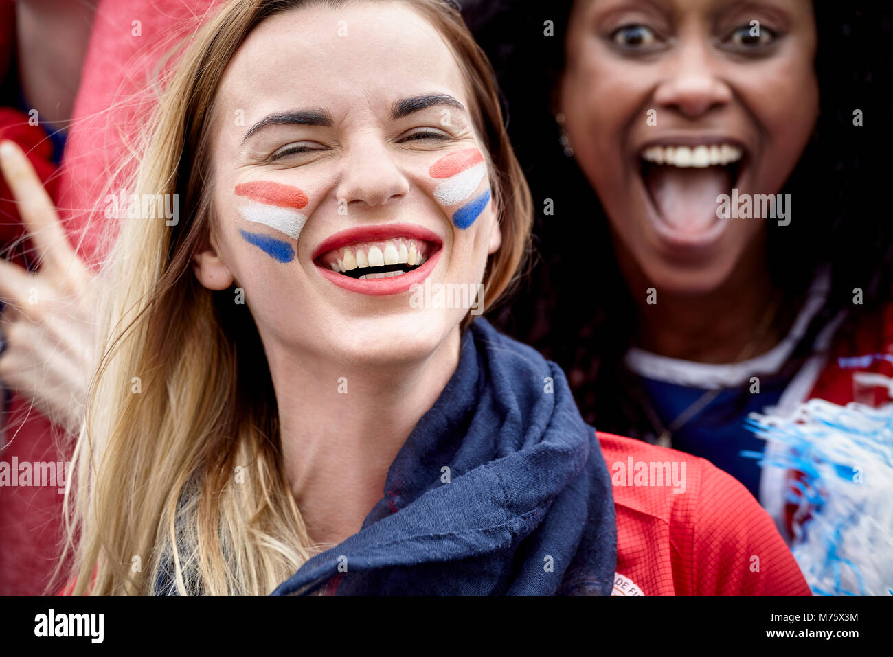 Los aficionados al fútbol francés sonriente y vitoreando en match Foto de stock
