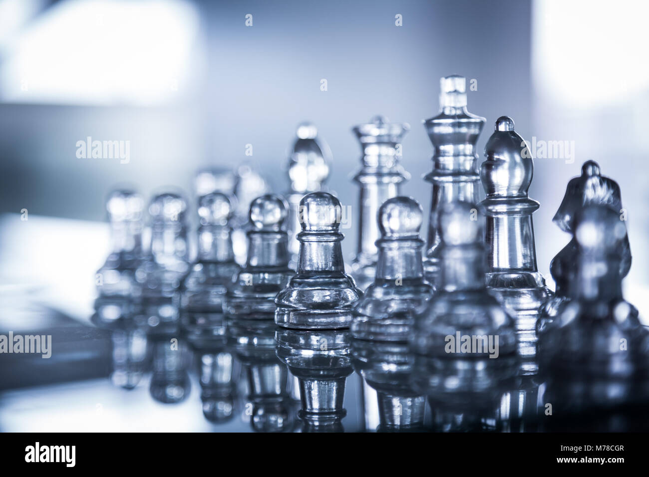 Ajedrez de cristal sobre un tablero de ajedrez. Foto de stock