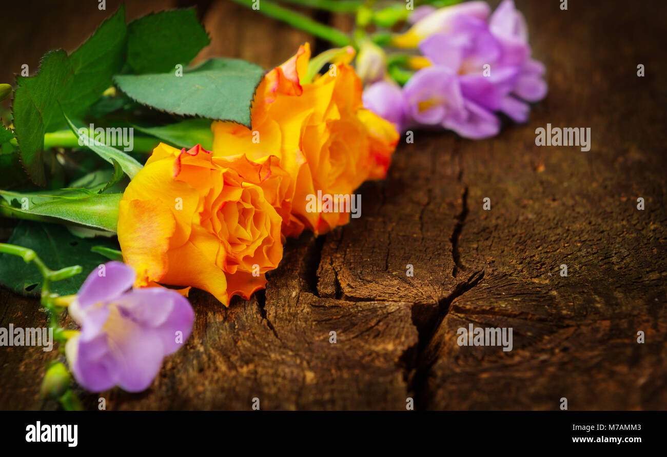 Rosas y fresias en madera Foto de stock