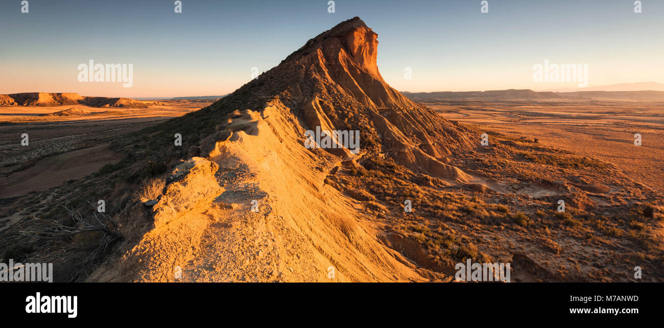 Vista panorámica de las montañas en la Bardena Reales desierto al atardecer con luz cegadora, Navarra, España Foto de stock