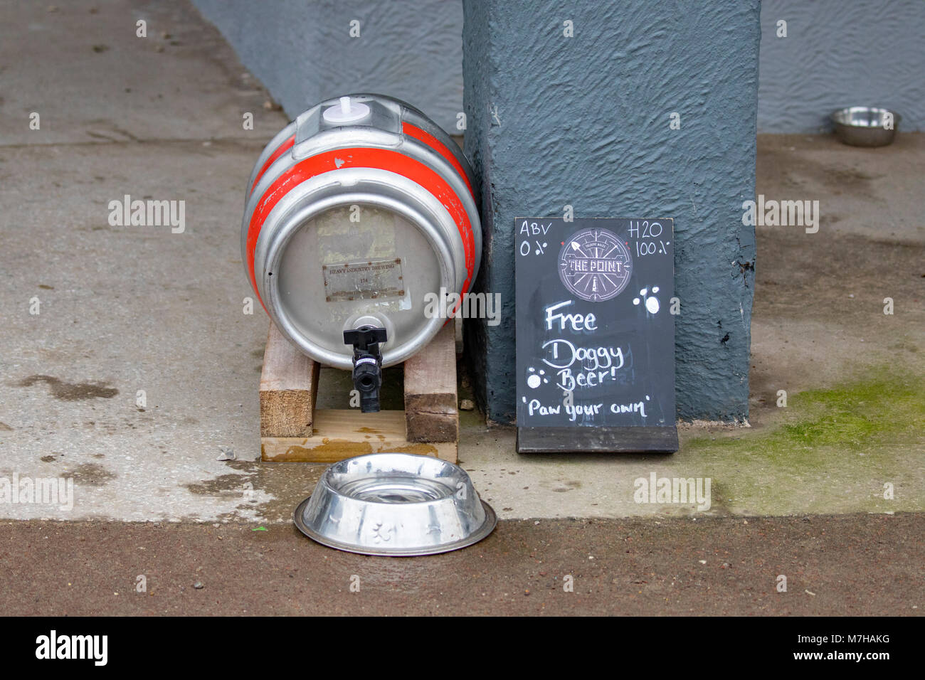 Un barril de cerveza barril convierten a verter agua en un bebedero de perro fuera de un pub con las palabras "doggy cerveza gratis! Y 'pata' en su propio Talacre Foto de stock