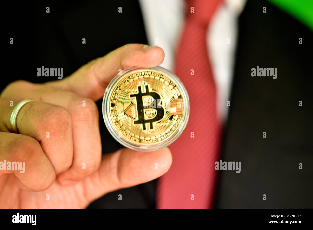 Irreconocible persona sosteniendo el color dorado bitcoin Foto de stock
