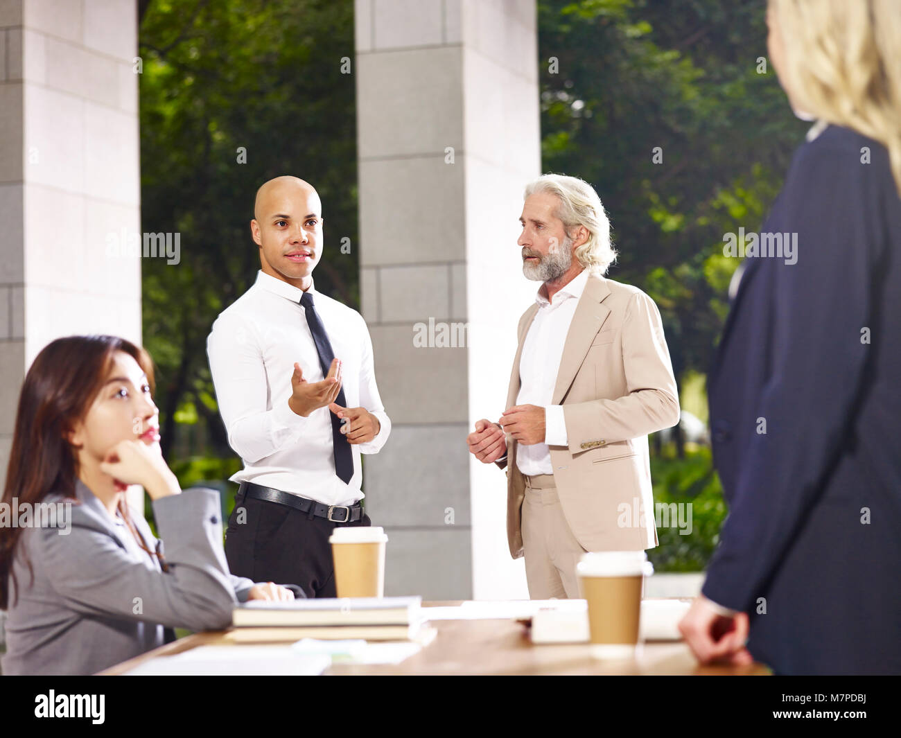 Ejecutivos corporativos multiétnica discutiendo debatiendo durante la reunión Foto de stock