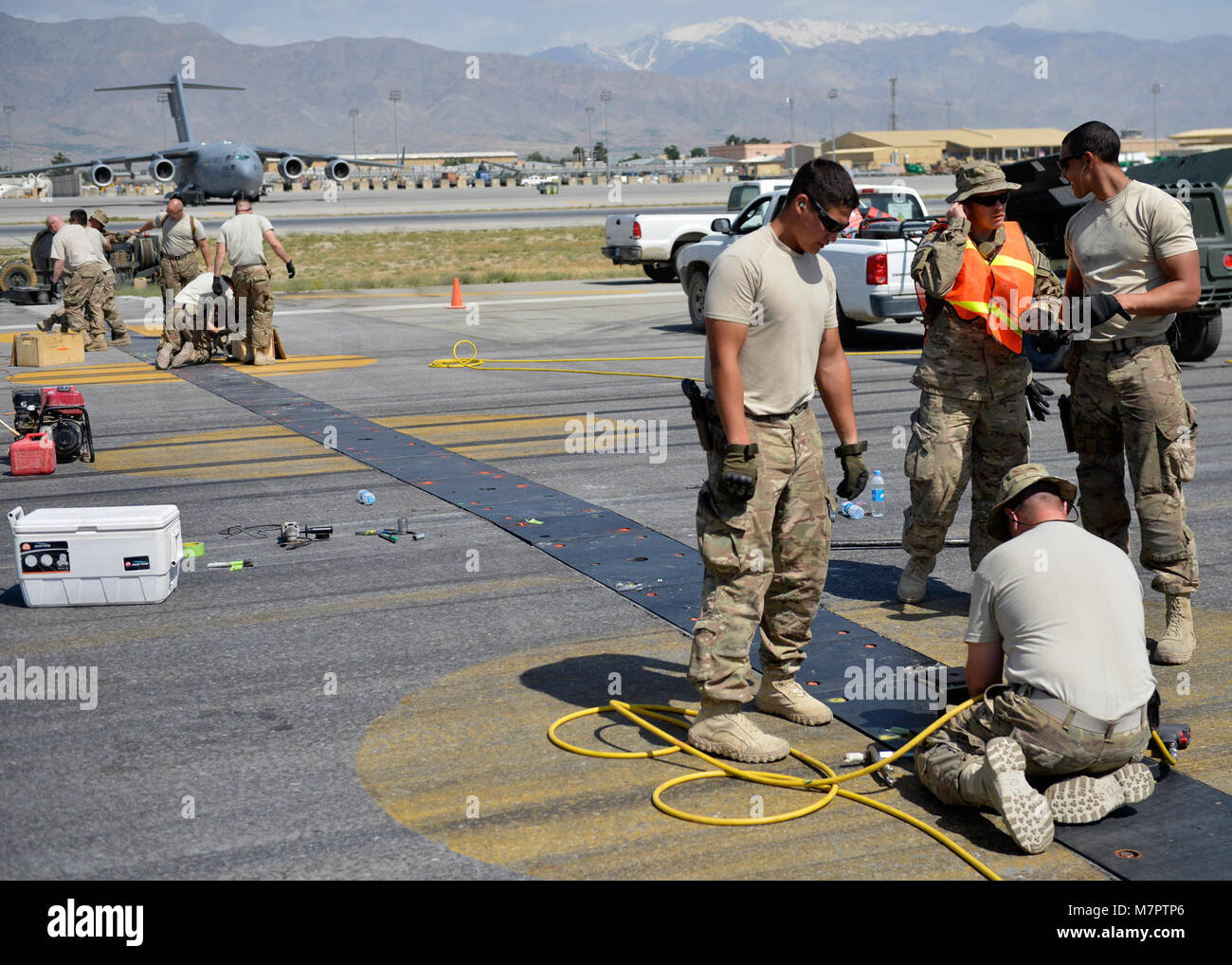 Pilotos de la Fuerza Aérea de los EE.UU con la 455Expedicionaria escuadrón de ingenieros civiles, esmerilar los pernos en un polly flightline pad en el aeródromo de Bagram, Afganistán, 5 de junio, 2014. Pulir los tornillos es necesaria para evitar que los aviones de reventar los neumáticos cuando se ejecuta a través de la almohadilla de Polly. (Ee.Uu. Foto de la fuerza aérea por el Sargento. Evelyn Chávez/liberado) 455a ala expedicionaria aérea aeródromo de Bagram, Afganistán Foto de stock