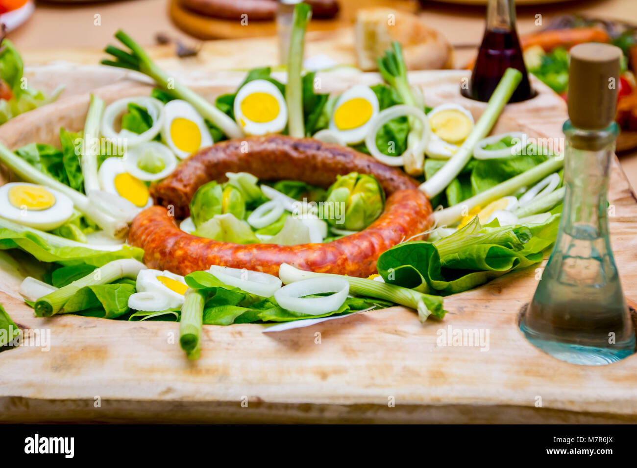 Los embutidos están decoradas con verduras frescas y huevos duros cortados  están expuestos en el tazón de madera tradicionales Fotografía de stock -  Alamy