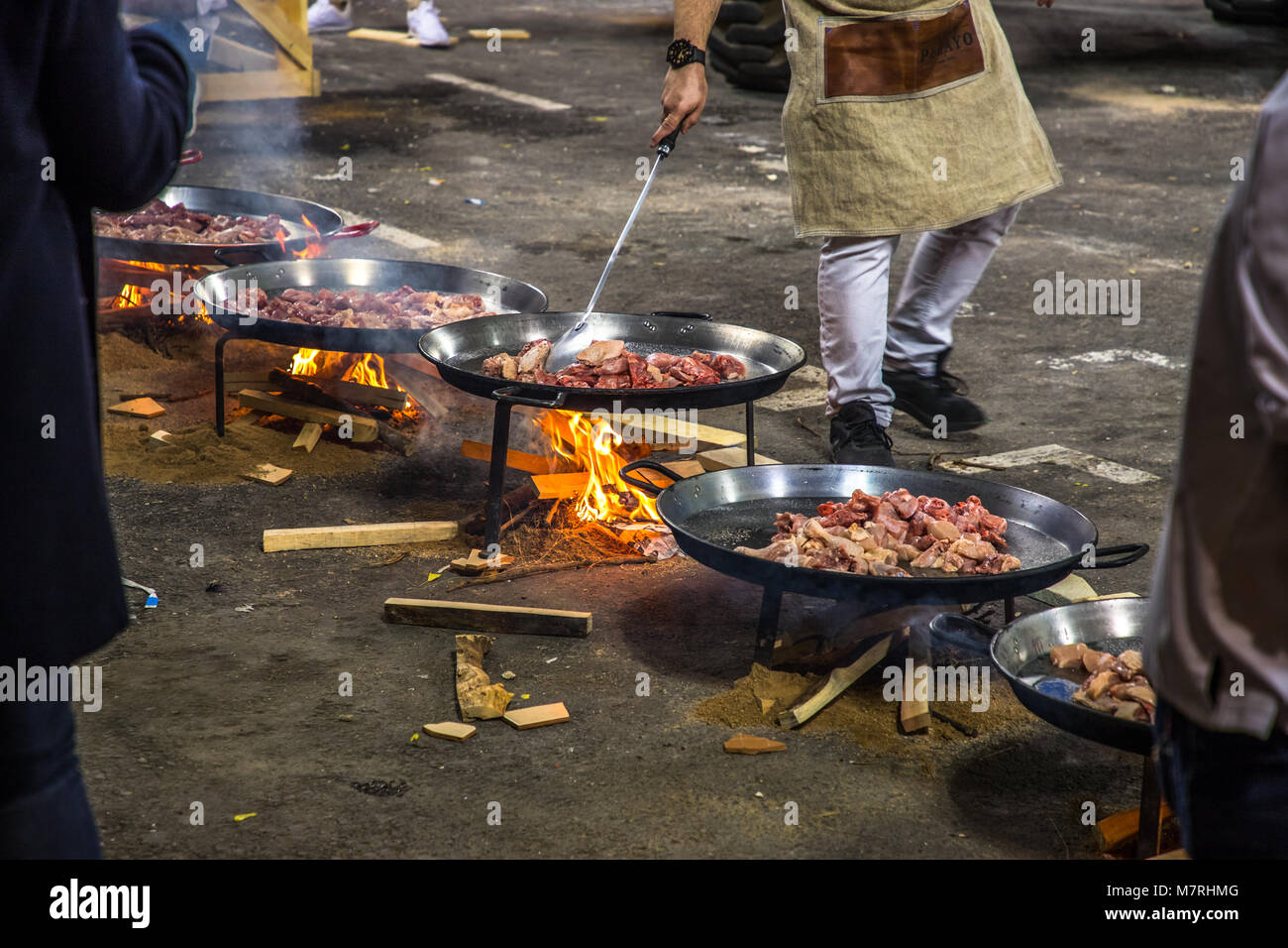 VALENCIA, ESPAÑA - 3/12/2018: fila de paella sartenes con carne cocinar  encima de un fuego abierto para alimentar a la tripulación que está  construyendo los ninots de fallas Fotografía de stock - Alamy