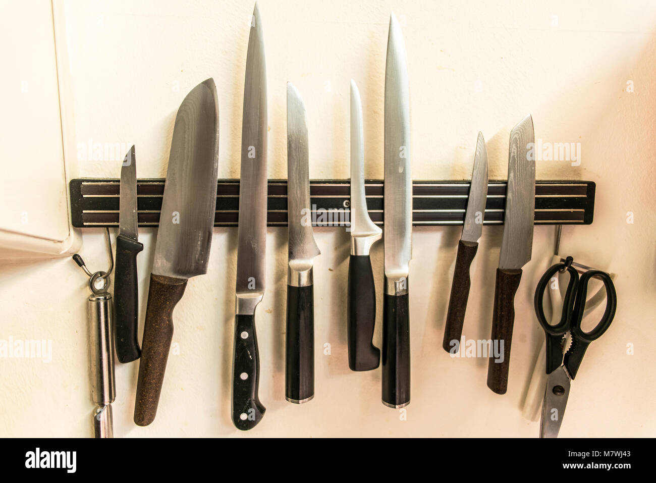 Un juego de cocina de alta calidad cocinero cuchillos herramientas sobre un  imán junta colgado en la pared Fotografía de stock - Alamy