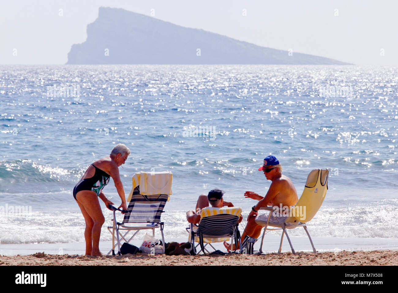 Los jubilados con Isla Benidorm / L'illa de Benidorm / La isla de Benidorm, en el fondo, Benidorm, provincia de Alicante, España Foto de stock
