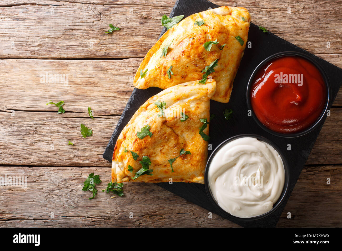 Comida italiana: pizza calzone con carne, verduras y queso de cerca en la  tabla. Vista superior horizontal desde arriba Fotografía de stock - Alamy