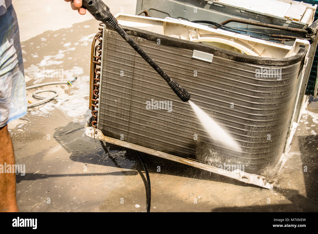 Un electricista profesional es la limpieza del aire acondicionado de ventana  en el techo de una casa con su pistola de agua a alta presión Fotografía de  stock - Alamy