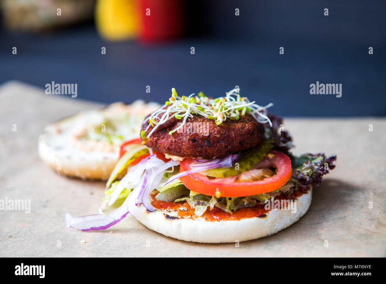 Quinoa burger, vegan comida callejera con tomate y hierbas de germinación. Foto de stock