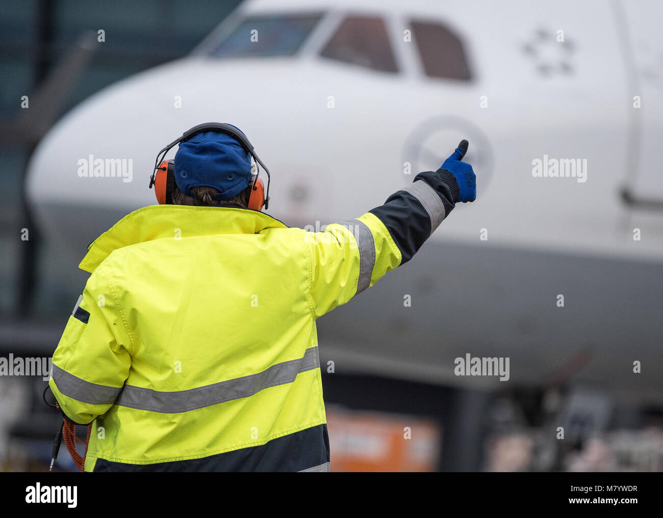 08 de marzo de 2018, Alemania, Frankfurt: Sabrina Boock, encargado de las operaciones de manipulación de tierra, da el 'Borrar todo' a la cabina de un Airbus A 321 aviones de pasajeros en el aeropuerto de Frankfurt. Con ocasión del Día Internacional de la mujer todas las posiciones operativas de vuelo Lufthansa LH 174, incluida la tripulación de cabina, cabina y en la plataforma están dotadas con las mujeres. La única excepción es la carga del equipaje y el embarque, el cual todavía está integrada por hombres debido a regulaciones laborales de seguridad y salud. Foto: Fabian Sommer/dpa Foto de stock