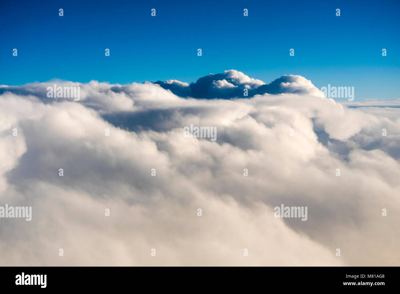 Vista aérea sobre las nubes cúmulos desde una ventana del avión durante el vuelo Foto de stock