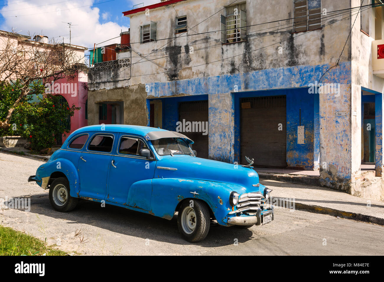 1950 Modelo viejo coche descendiendo una pendiente en un pequeño pueblo de Cuba Foto de stock