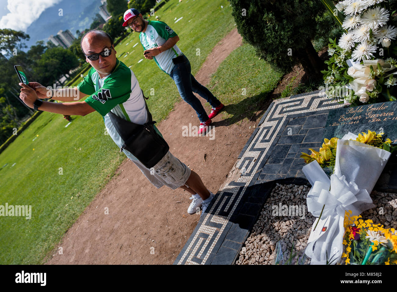 Un hombre colombiano toma una fotografía mientras selfie visitando la tumba del narcotraficante
