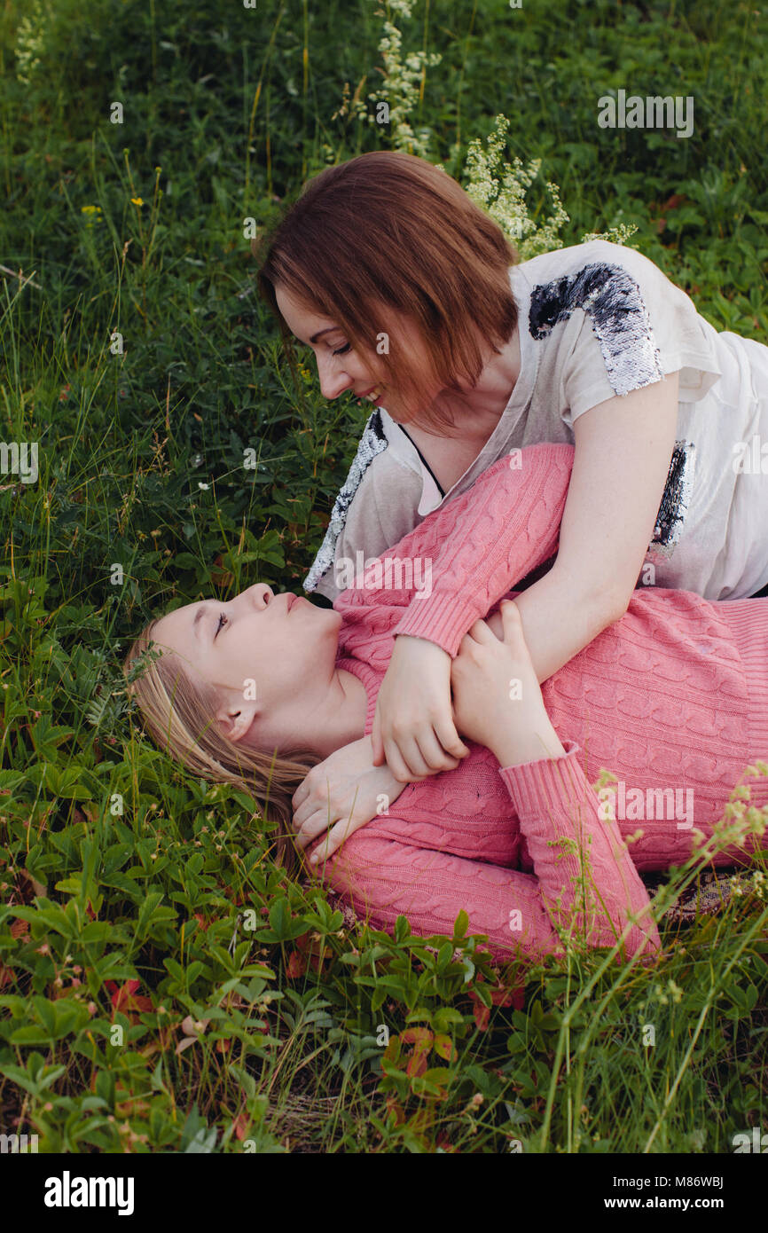 Madre e hija jugando en un prado Foto de stock