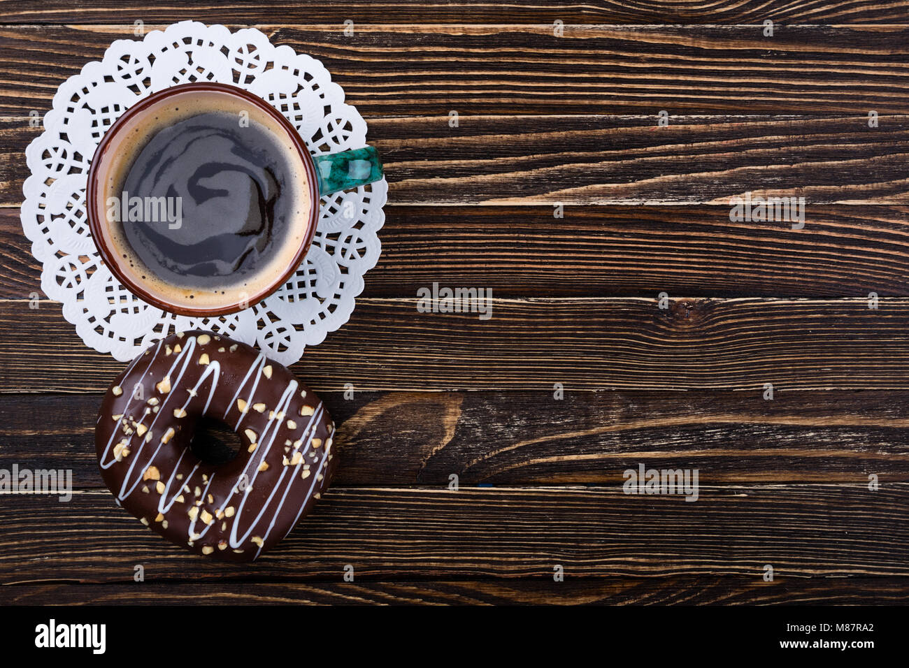 Taza de café y donut en mesa de madera. Desayuno oncept. Vista superior, espacio de copia Foto de stock