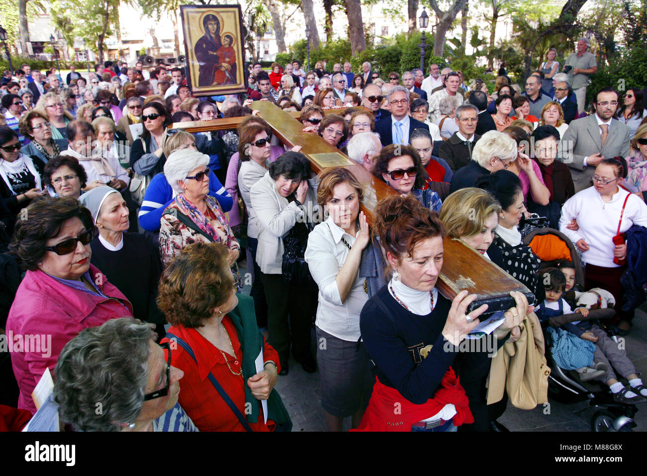 Las mujeres que llevaban una cruz de madera durante una procesión religiosa, Ronda, Andalucia, Spain Foto de stock
