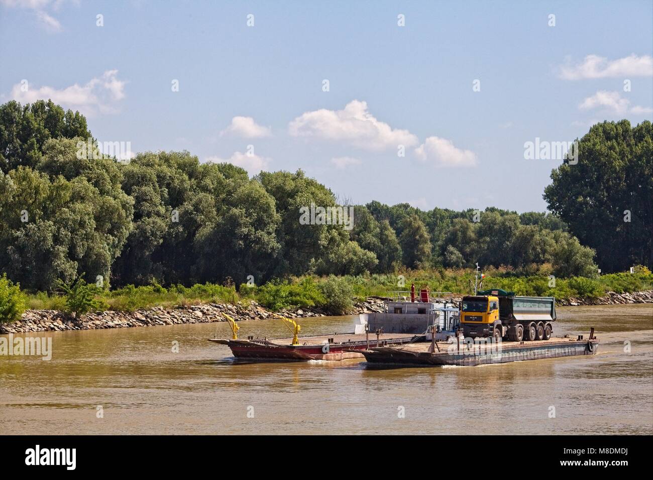 Mover un camión volquete en una barcaza aguas abajo de Tulcea, en el delta del río Danubio Foto de stock