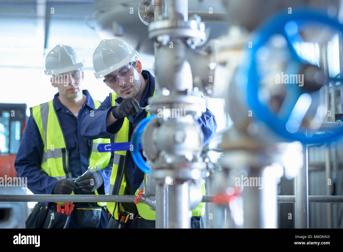 Aprendiz ingenieros trabajando en ducto en el producto industrial facility Foto de stock