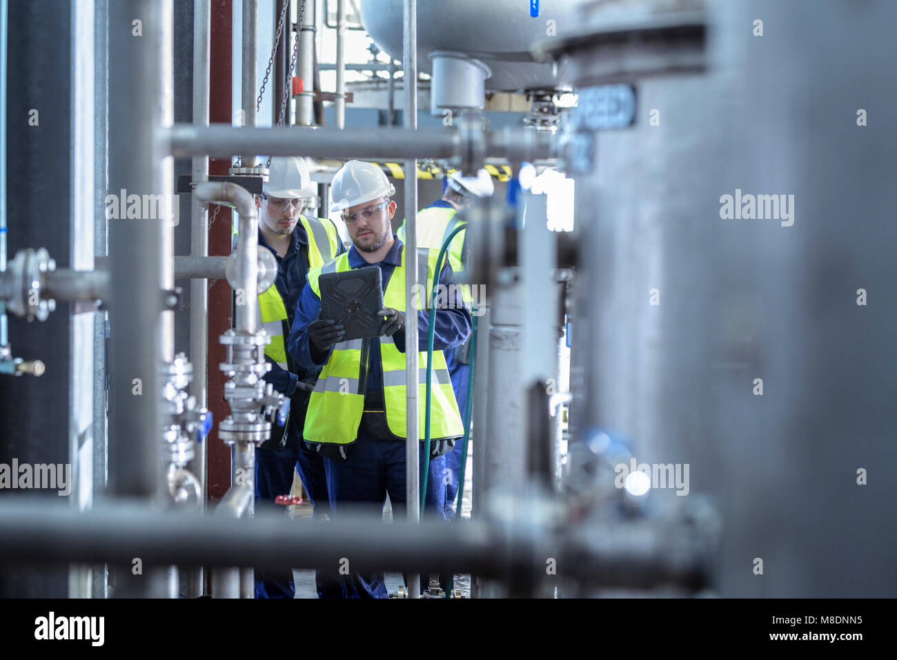 Aprendiz ingenieros trabajando en ducto en el producto industrial facility Foto de stock