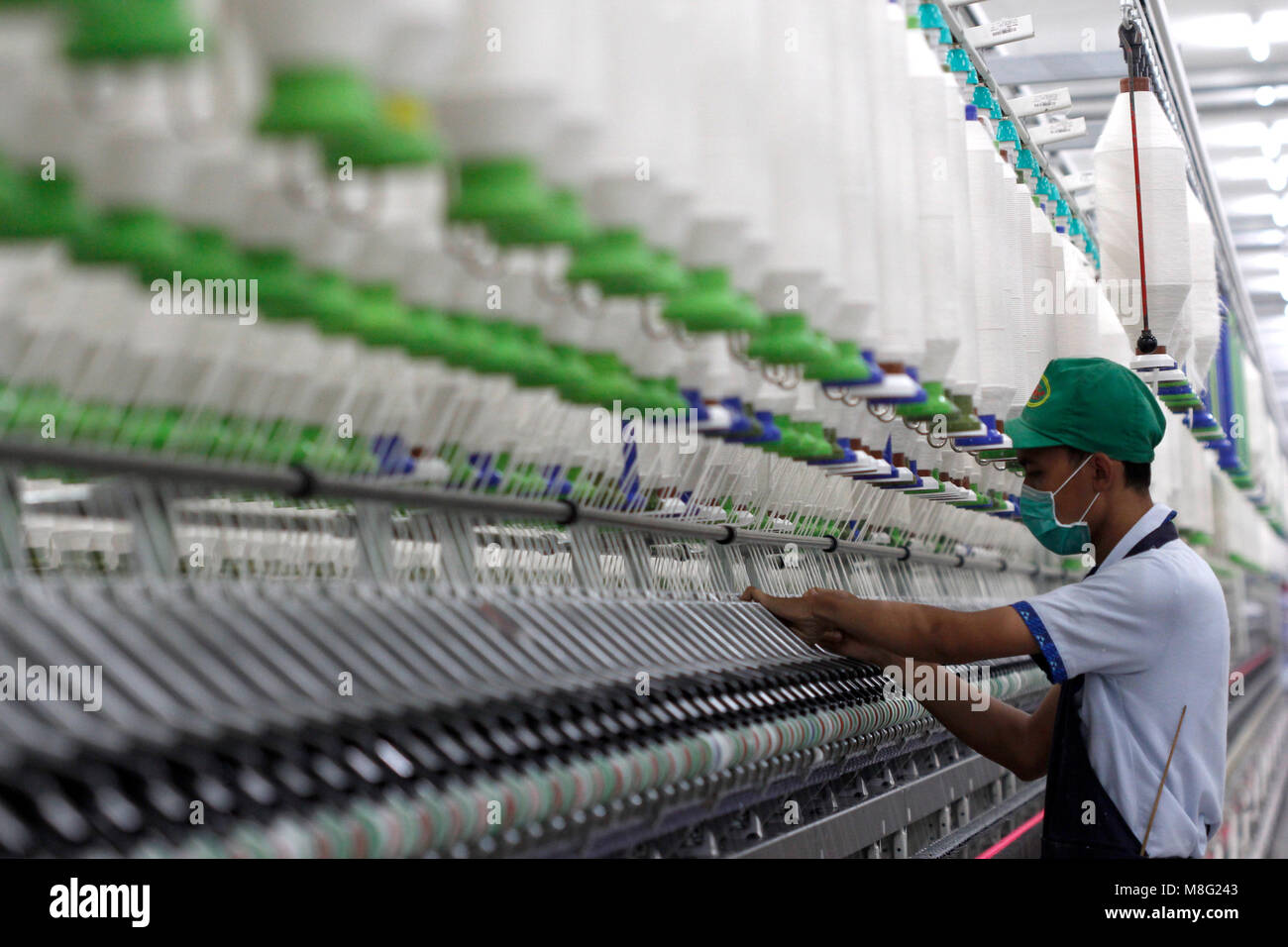 Sukoharjo, Indonesia. 15 Mar, 2018. Un trabajador inspecciona las roscas en  un hilo en el área de la máquina girando en un PT Sri Rejeki Isman (Sritex)  en fábrica Sukoharjo, Java, Indonesia.