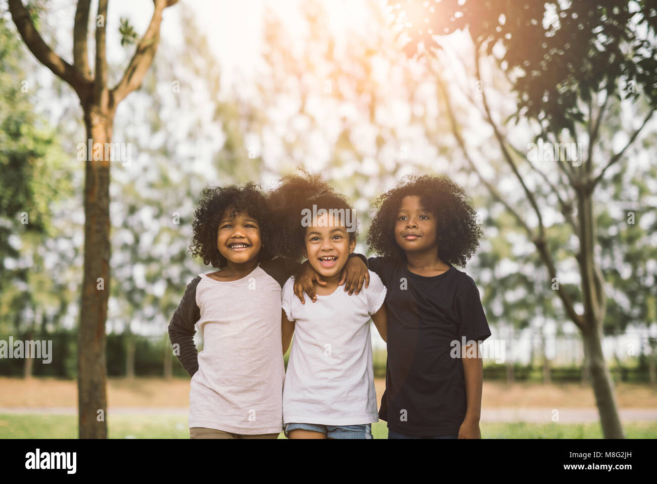 Los niños amistad compañerismo sonriente felicidad concepto.afroamericano cute little Boy y Girl abrazo cada otro día soleado en verano Foto de stock