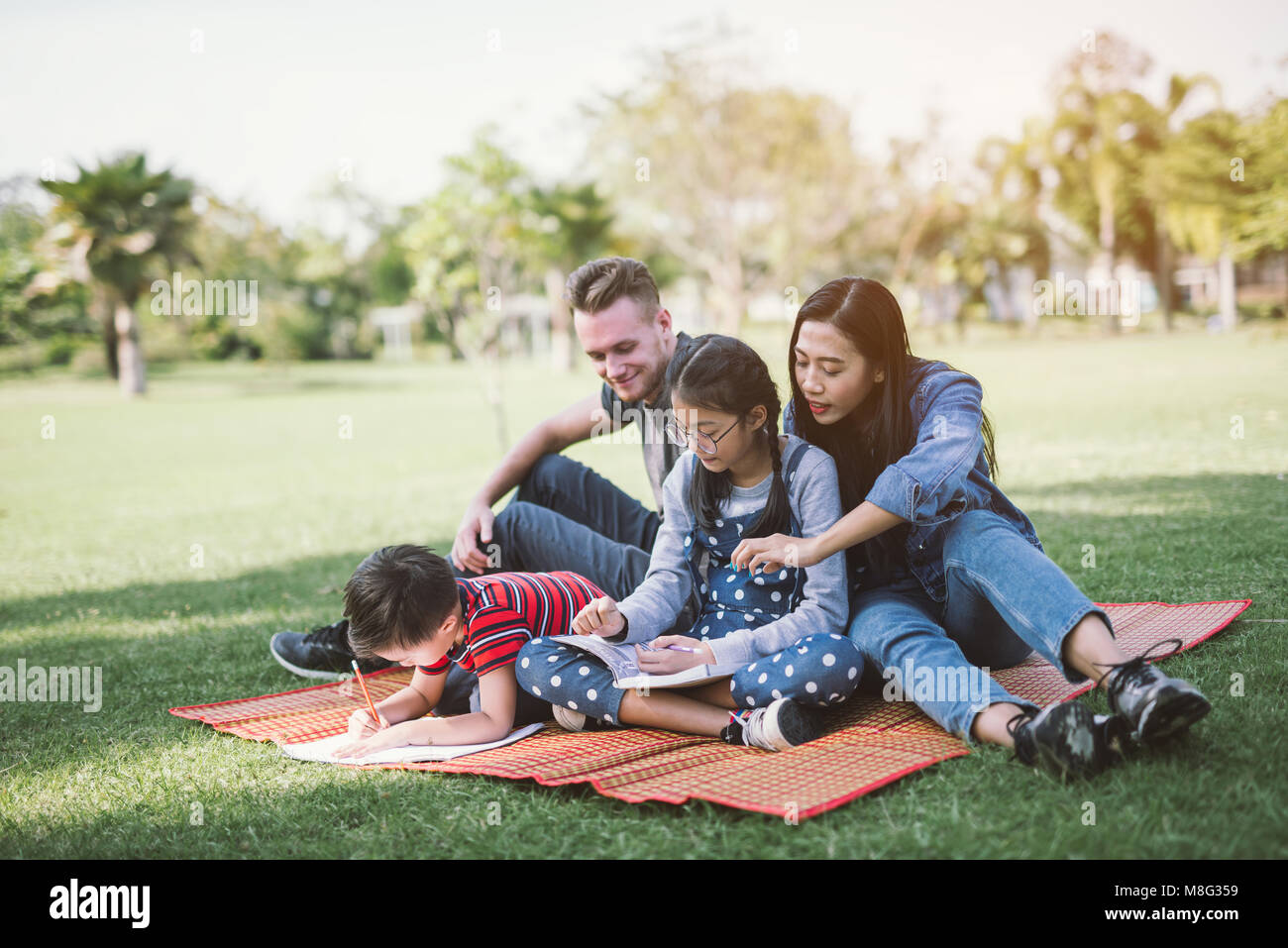El padre, la madre y su hijo e hija. Padres e hijos haciendo los deberes  Fotografía de stock - Alamy