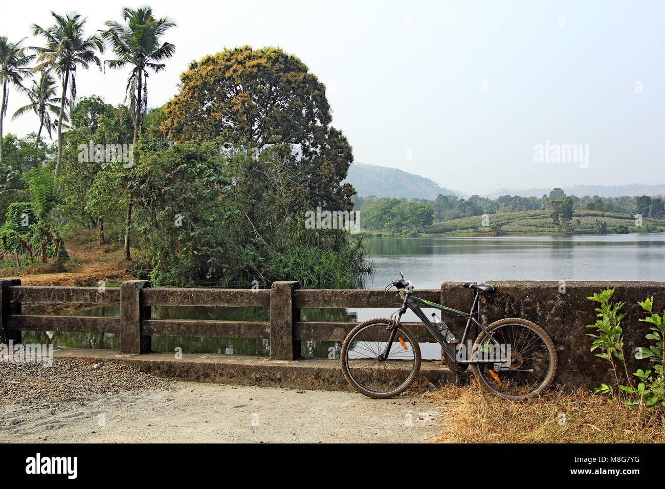 Bicicleta Bicicleta todoterreno aparcado mientras a lo largo de la pintoresca campiña con lagos y lagunas en Kerala, India Foto de stock
