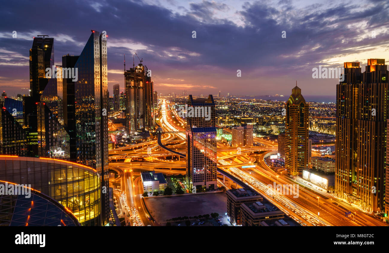 Vista de pájaro del horizonte de Dubai y la hora pico de tráfico en el centro de la ciudad por la noche Foto de stock