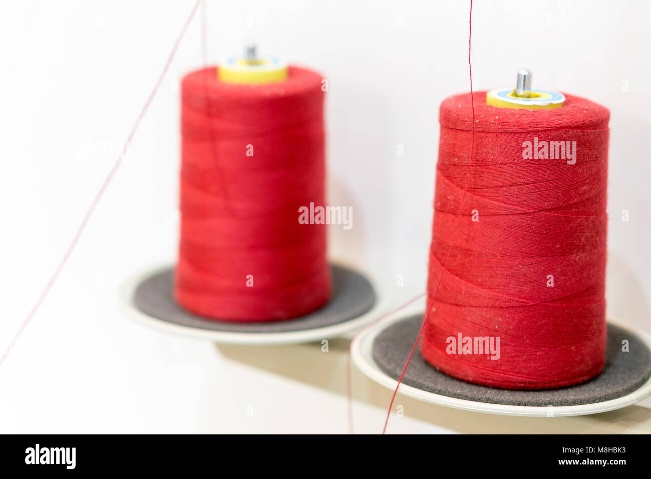 Dos bobinas de hilo rojo. Hilos para máquinas de coser industriales  Fotografía de stock - Alamy