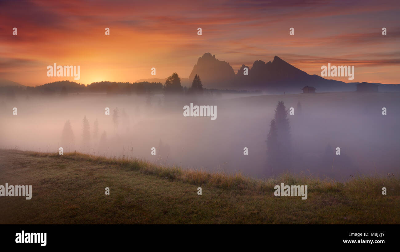 Misty vista horizontal en Alpe di Siusi o Alm Seiser en hermoso amanecer. La larga exposición foto: Cordillera de los Dolomitas, Italia. Foto de stock