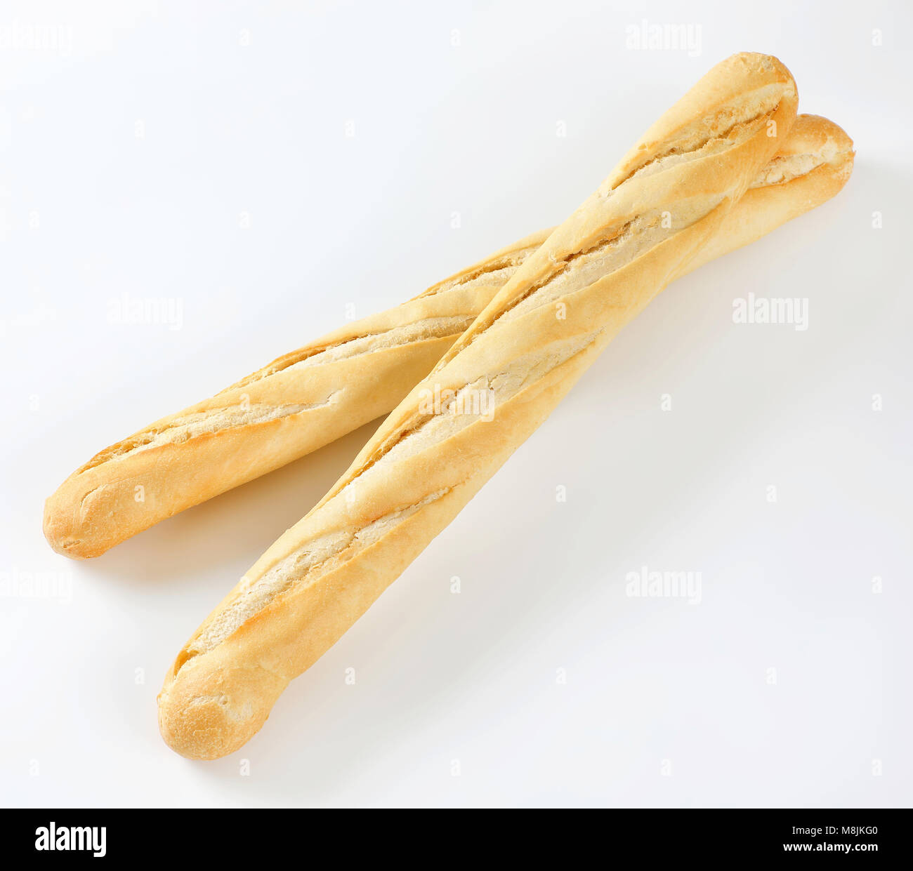 Dos largas baguettes francesas sobre fondo blanco. Foto de stock