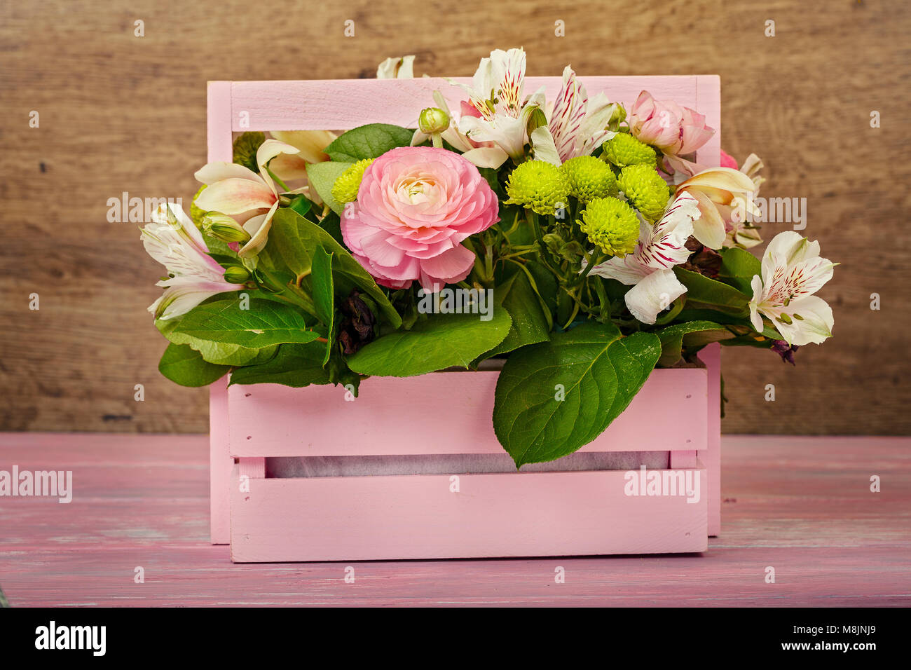 Arreglos con flores en una caja de madera rosa Fotografía de stock - Alamy