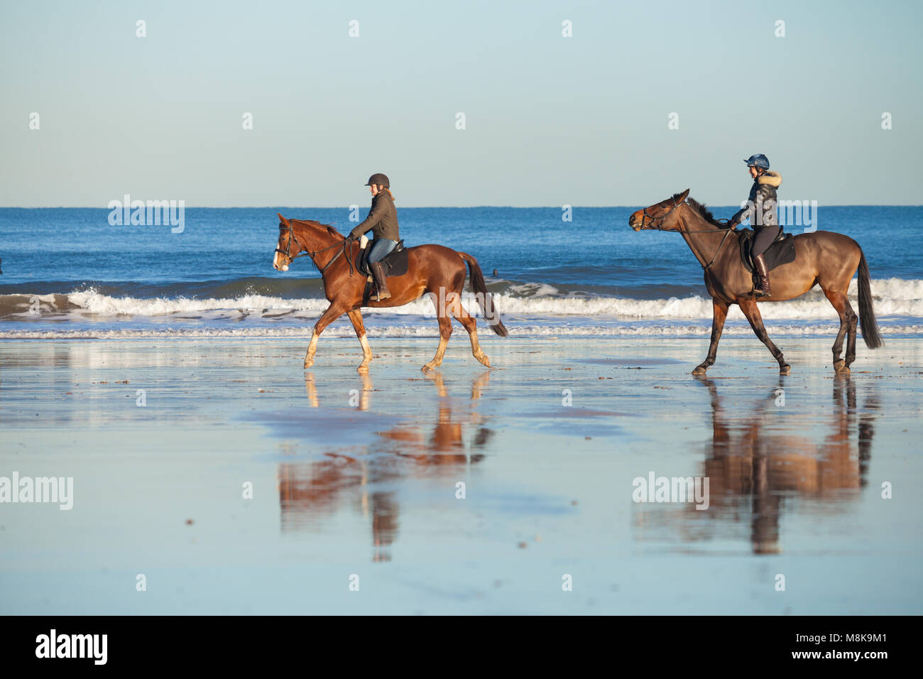 Dos personas a caballo en la playa en North Berwick Escocia. Foto de stock