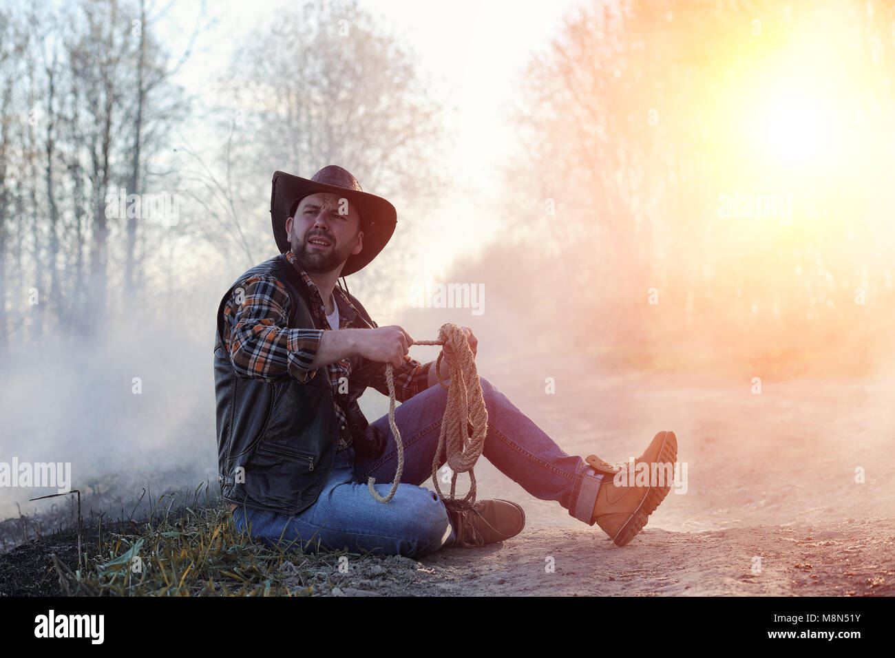 Un hombre lleva un sombrero de vaquero y loso en el campo. American  Fotografía de stock - Alamy