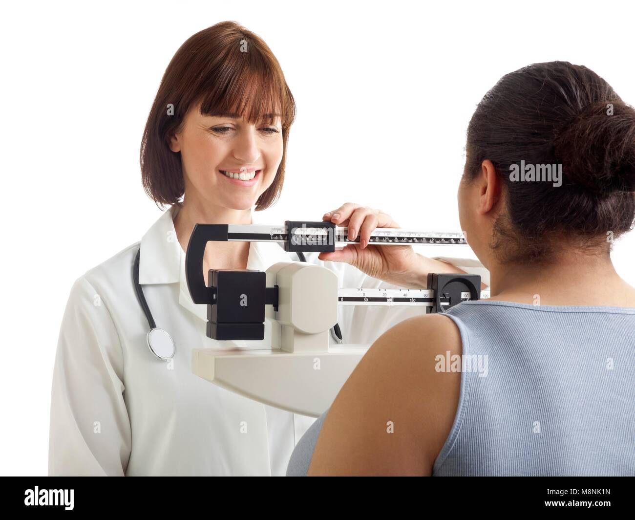 Doctor pesando la mujer escalas. Foto de stock