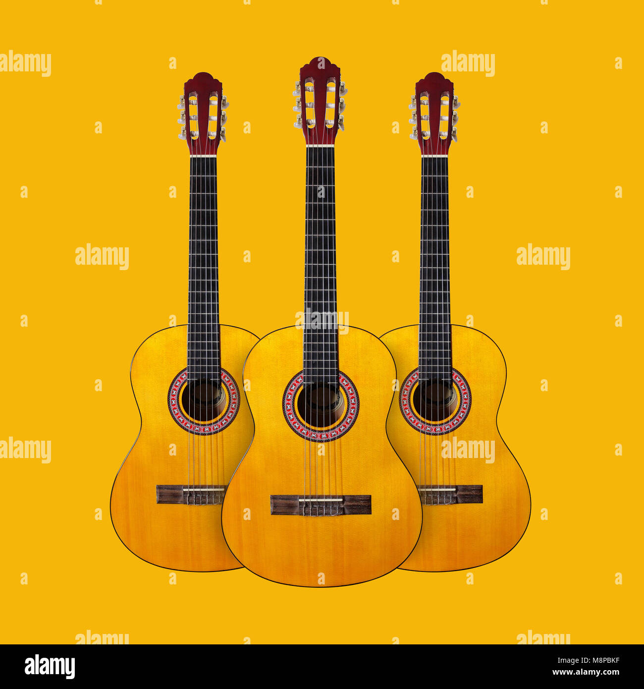 Tres instrumentos musicales guitarra clásica sobre un fondo amarillo  Fotografía de stock - Alamy