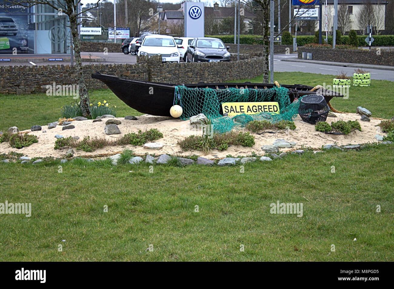 Barco compraventa pactado como decoración en el camino de una rotonda en skibbereen, West Cork, Irlanda Foto de stock