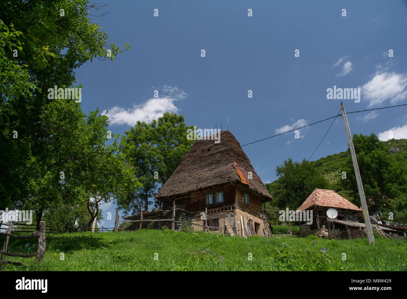 Tradicional casa de madera cubierto con paja en montañas Apuseni, Transilvania, Rumania. La arquitectura vernácula. Foto de stock