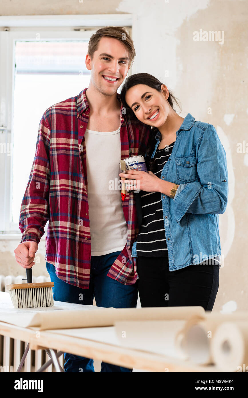 Retrato de una joven pareja feliz celebración herramientas para remodelar la casa Foto de stock