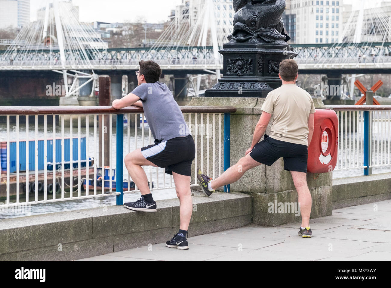 Los corredores estiramiento antes de correr en el Southbank de Londres. Foto de stock