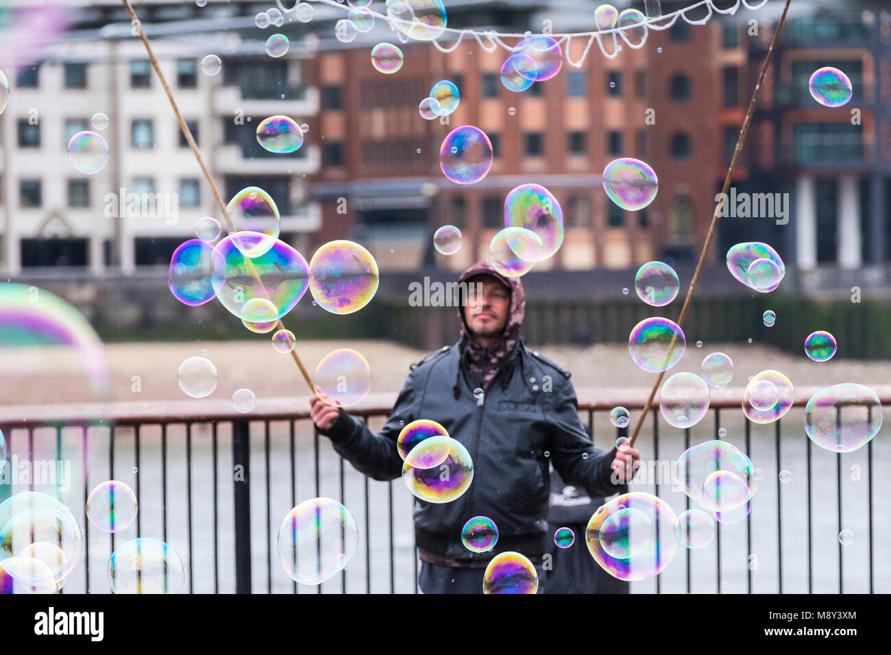 Un hombre la creación de burbujas de colores en la orilla sur de Londres. Foto de stock