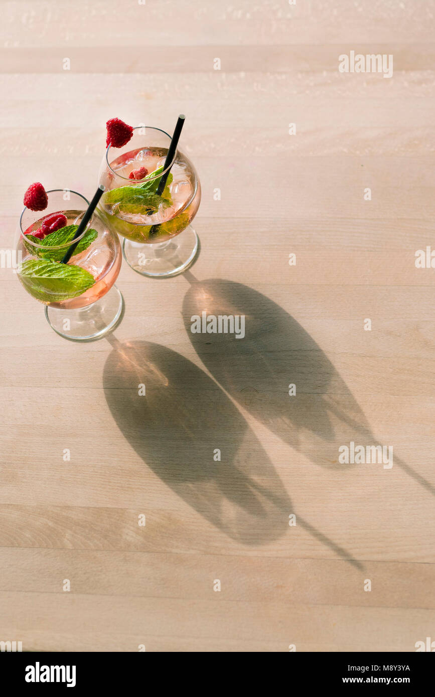 Dos cóctel de bebidas en una mesa proyecten sombras en la luz del atardecer. Foto de stock