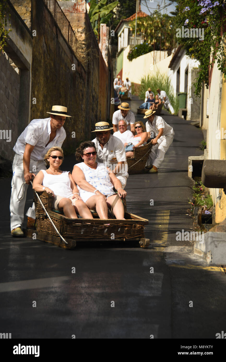 Los turistas bajando una colina en una cesta de mimbre tobogán Foto de stock